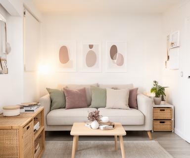 Departamento pequeño con decoración funcional, almohadones neutros y cuadros minimalistas que optimizan el espacio